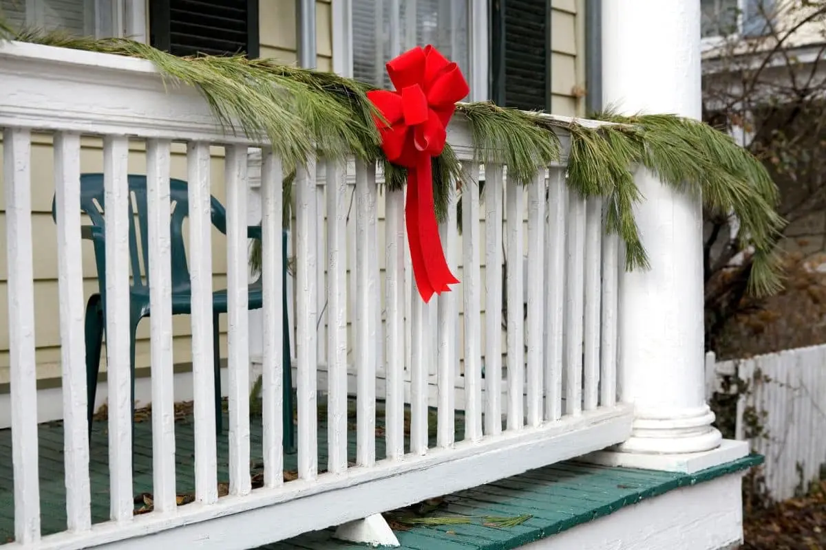 Outdoor Christmas decor uses greenery, wreaths, and natural elements to enhance curb appeal.