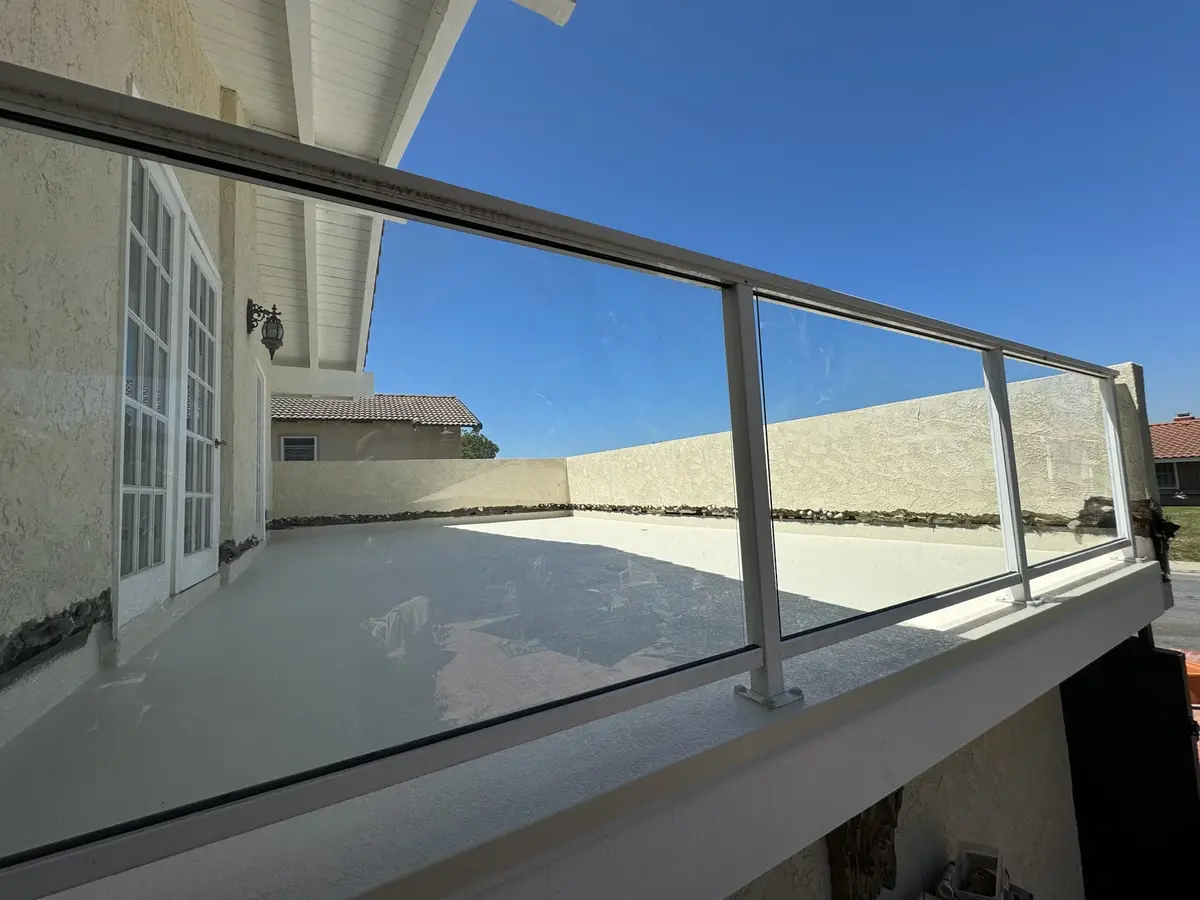 Finished safety decking with glass railing and clean completed outdoor deck surface