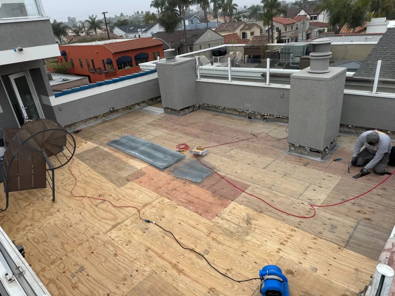 Installer laying rooftop deck tiles on an outdoor deck surface