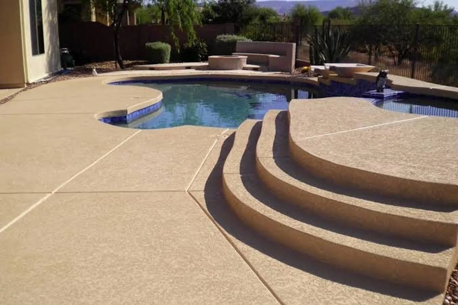 Finished outdoor deck surface with pool and steps