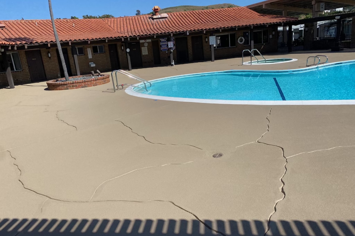 Spiderweb cracking on a concrete pool deck—an early warning sign of deeper structural issues that require professional resurfacing.